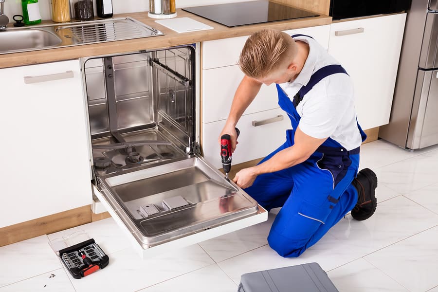 Dishwasher repair technician fixing built-in dishwasher in Dubai kitchen